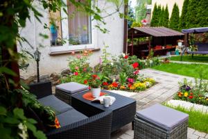 een patio met een tafel, stoelen en bloemen bij noclegi u zabki in Ełk