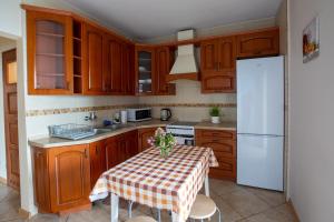 een keuken met een tafel en een witte koelkast bij noclegi u zabki in Ełk