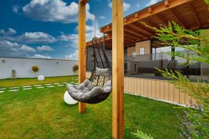 a swing in a yard with a house at Peninsula Luxury & Spa in Năvodari
