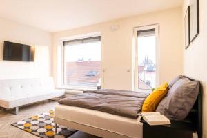 1 dormitorio con cama y ventana grande en Brno Center View Apartement A - with self check-in, en Brno