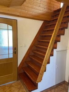 uma escada de madeira num quarto com uma porta em Chata v zátoce - Nechranice em Kadaň