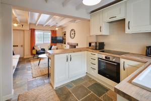 a kitchen with white cabinets and a living room at Host & Stay - Dale End in Kirkbymoorside