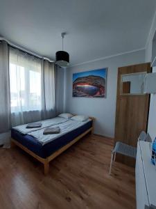 a bedroom with a bed and a large window at Pokoje Fiesta in Gdynia