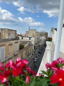 een balkon met bloemen en uitzicht op een stadsstraat bij A due passi da in Corato