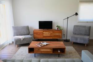 uma sala de estar com uma televisão e uma mesa de centro em Ericeira TreeGarden em Ericeira