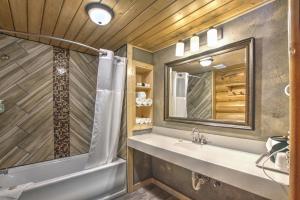 a bathroom with a tub and a sink and a mirror at Hibernation Station in West Yellowstone