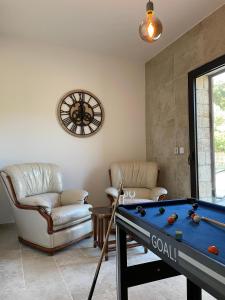 ein Wohnzimmer mit einem Billardtisch und Stühlen in der Unterkunft Villa Campana - Sartène in Sartène