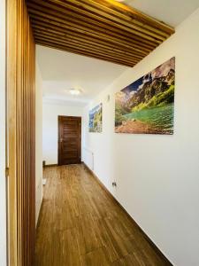 a hallway of a house with white walls and wooden floors at Gąsienicowy Widok in Poronin