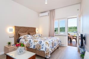 Apartment Bilice beach في بيليس: غرفة نوم بسرير كبير وتلفزيون