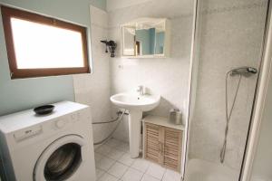 uma casa de banho com uma máquina de lavar roupa e um lavatório em Le petit Monlogis - Calme - Wi-Fi em Angoulême