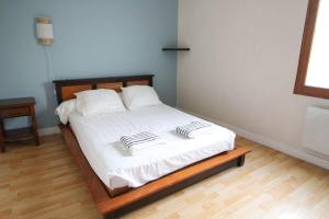 uma cama com duas almofadas num quarto em Le petit Monlogis - Calme - Wi-Fi em Angoulême