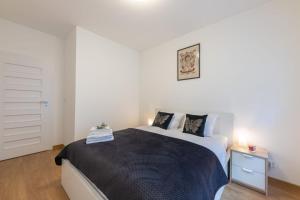1 dormitorio con 1 cama grande con manta negra en Harmony Deluxe by 3City Rentals en Gdansk