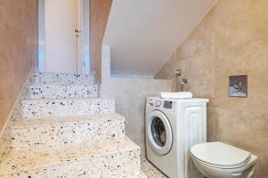 uma casa de banho com um WC e uma máquina de lavar roupa em Apartment Bilice beach em Bilice