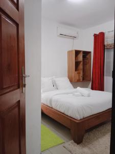 1 dormitorio con 2 camas y cortina roja en Résidence Hôtelière l'Océane, en Kribi