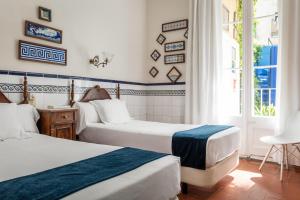 錫切斯的住宿－雷納新卡媒介酒店，酒店客房设有两张床和窗户。