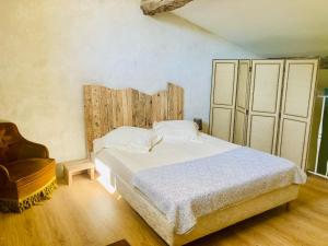 um quarto com uma cama e uma cadeira em Chambres et gîte en Cévennes em Cros