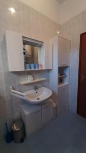 Baño blanco con lavabo y espejo en Quiet & Lovely Apartment-Ičići en Ičići