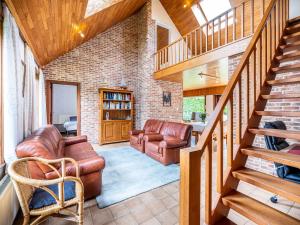 a living room with leather furniture and a staircase at Villa in St-Idesbald near Sea Beach in Koksijde