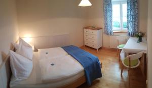 een slaapkamer met een bed, een bureau en een raam bij Wunderschöne Ferienwohnung mit Seeblick in Zell am Moos