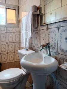 a bathroom with a toilet and a sink at Résidence Hôtelière l'Océane in Kribi