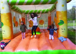 three children jumping on an inflatable play structure at Camping Parc Saint Sauvayre in Vagnas