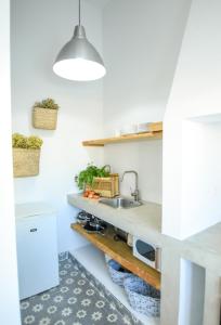 eine Küche mit einer Spüle und einer Theke in der Unterkunft Casa do Povo (casa com piscina no centro de Alcácer) in Alcácer do Sal