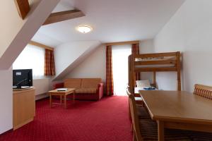Hotel Pension Kandolf في تامسويغ: غرفة معيشة مع أريكة وطاولة