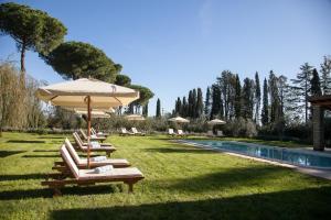 een rij ligstoelen met een parasol naast een zwembad bij Poggio delle Molare Adults-Only Retreat in Bracciano