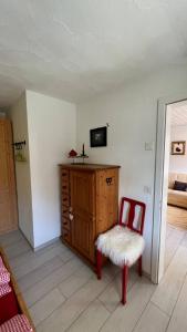 a room with a wooden cabinet and a chair at Cozy 2 Room Appartment In Laax in Laax