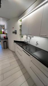 a kitchen with white cabinets and a black counter top at Cozy 2 Room Appartment In Laax in Laax