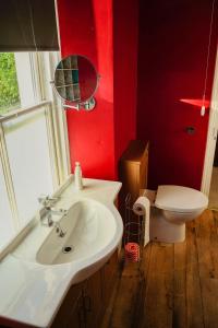 a bathroom with a white sink and a toilet at Manorbier House - St Anne's Room in Tenby