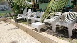 a row of white chairs sitting next to a wall at Résidence Hôtelière l'Océane in Kribi