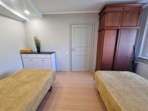 - une chambre avec deux lits, une armoire et une porte dans l'établissement Naftininkų g. 8, à Mažeikiai