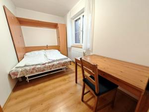 1 dormitorio con cama, escritorio y ventana en Špičák sruby - Horní dům, en Špičák