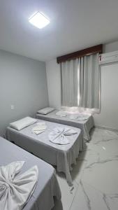 Habitación hospitalaria con 2 camas y ventana en Condomínio Golden Dolphin Village, en Porto Seguro