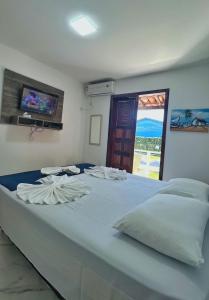 Cama grande azul en habitación con ventana en Condomínio Golden Dolphin Village, en Porto Seguro