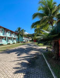 una calle adoquinada con una palmera y edificios en Condomínio Golden Dolphin Village, en Porto Seguro