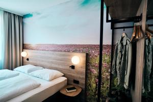 una camera con 2 letti e un murale floreale di I'M INN Zwettl - Hotel zum Brauhaus a Zwettl-Niederösterreich