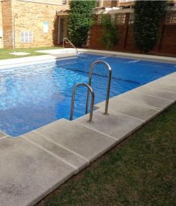 a swimming pool with two metal rails next to it at Aguadulce Normandos in Roquetas de Mar