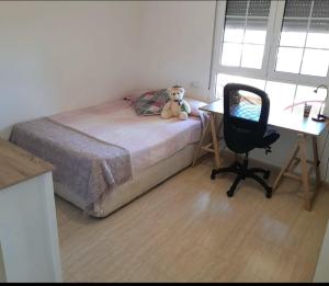 a bedroom with a bed and a desk with a teddy bear on it at Aguadulce Normandos in Roquetas de Mar