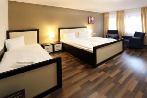 una camera d'albergo con due letti e una sedia di Hotel Corona a Kaplice