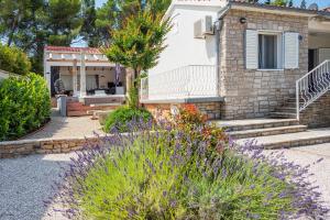 a house with a garden with flowers in front of it at Holiday House de Finis in Sutivan