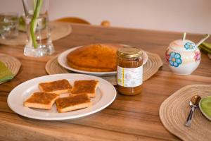 a table with a plate of toast and a jar of honey at LA TORRE DEL MANGHEN: Agri-alloggio indipendente in Rota d'Imagna