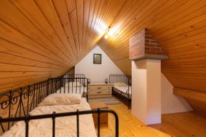 a attic bedroom with a large wooden ceiling at Mala hiša in Solčava