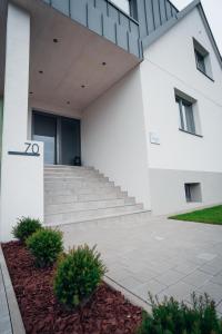 un edificio blanco con escaleras delante en Pur-INN das Gästehaus, en Purbach am Neusiedlersee
