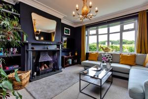 a living room with a couch and a fireplace at Finest Retreats - Cresswell House in Cresswell