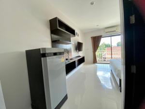 a kitchen with a refrigerator in the middle of a room at SD Residence I Naiyang Beach I HKT Airport in Ban Bo Han