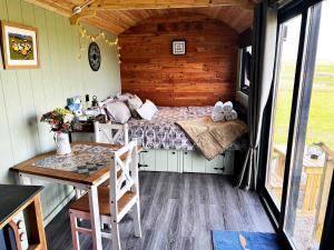 ein Schlafzimmer mit einem Bett und einem Tisch in einem Zimmer in der Unterkunft Luxury Shepherd Hut in the Peak District in Bakewell