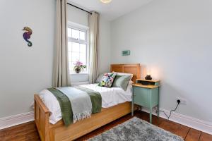 a bedroom with a bed and a window and a table at Finest Retreats - Cresswell House in Cresswell