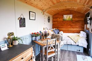 Un dormitorio con una cama, un escritorio y una mesa. en Luxury Shepherd Hut in the Peak District, en Bakewell 47 fotos más